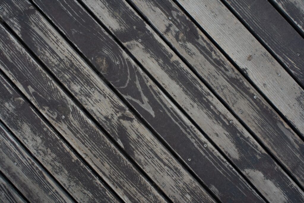 Homeowner and professional worker discussing the condition of a wooden backyard deck before cleaning.