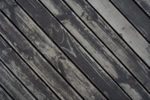 Homeowner and professional worker discussing the condition of a wooden backyard deck before cleaning.